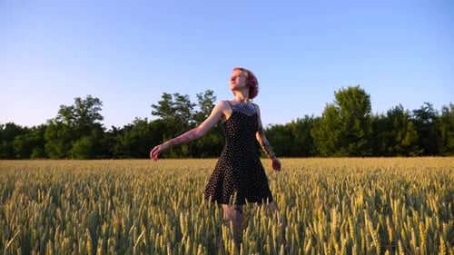 Happy Female Hipster with Pink Hair Walking Through Green Barley Field at Sunset Pretty Punk Girl