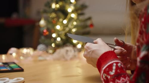 Woman crafts paper for Christmas tree