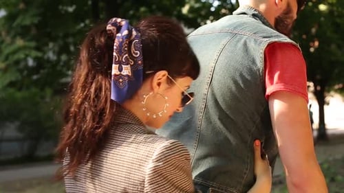 Vista traseira de uma mulher abraçando um homem se divertindo andando de bicicleta. Jovem casal andando de bicicleta juntos em