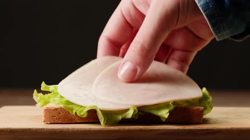 Assembling a Delicious Sandwich on Wooden Board