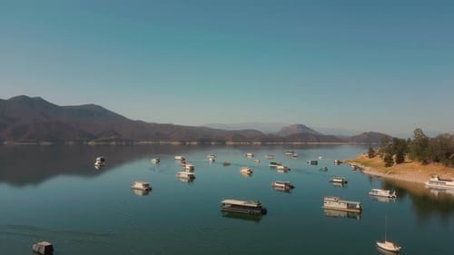 Aerial drone flying over a lake, water dam, with mountains at sunrise. Beautifull dreamy landscape v