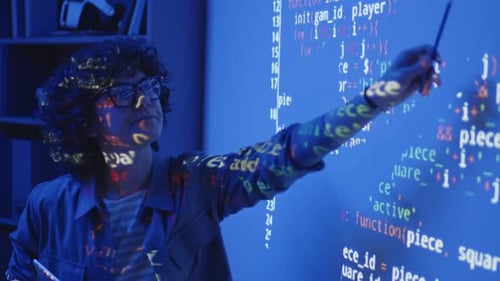 Software Developer Explaining Code in Blue Lit Office