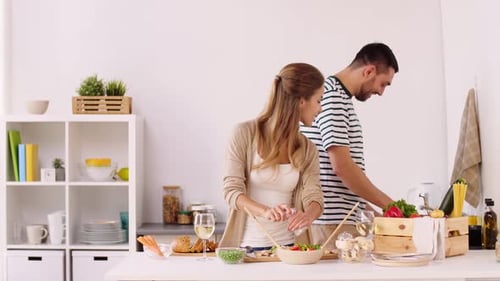 Concepto de personas y estilo de vida: pareja feliz cocinando comida y divirtiéndose