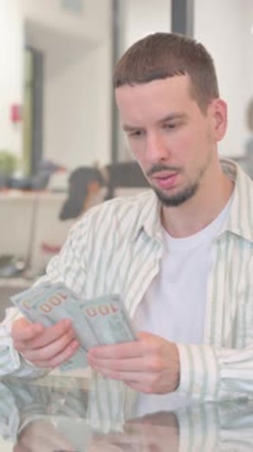 Creative Young Man Counting Money in Office, vertical video