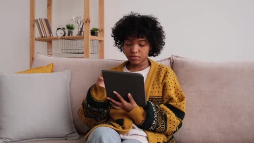 Woman Relaxing on Couch Using Tablet at Home