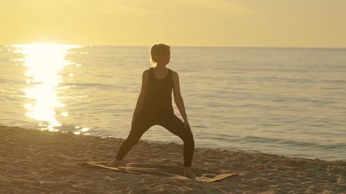 Slim Adult Woman on Beach at Beautiful Sunset Practice Yoga Breathing Techniques Standing in