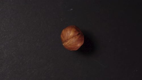 Peeled hazelnuts. Rotates on a black background. a handful of nuts fall from above. close-up.