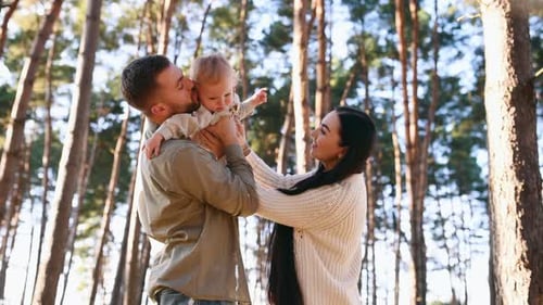 Loving Family and Baby in a Sunny Forest
