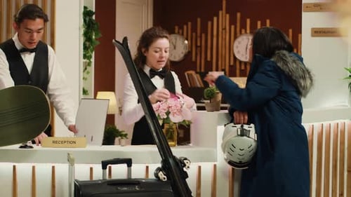 Hotel Receptionists Assisting Guests with Winter Gear