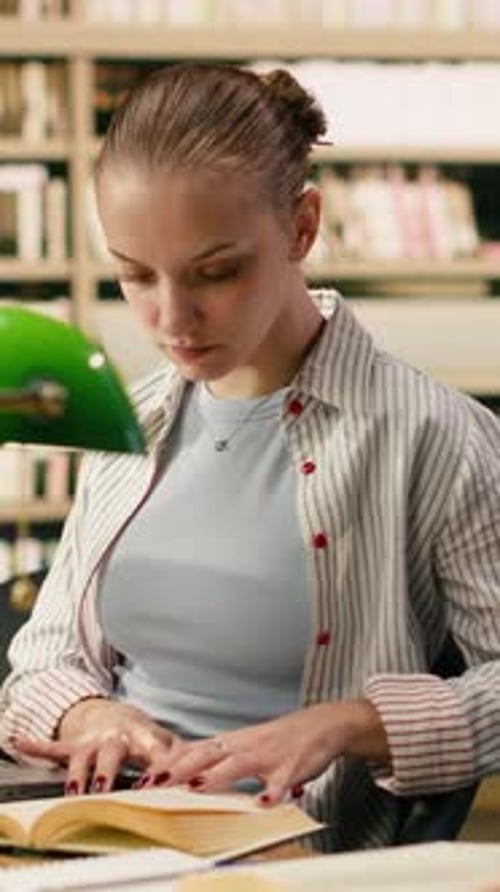 Vertical Video Portrait of Smiling Student Pauses From Reading and Taking Notes on Laptop