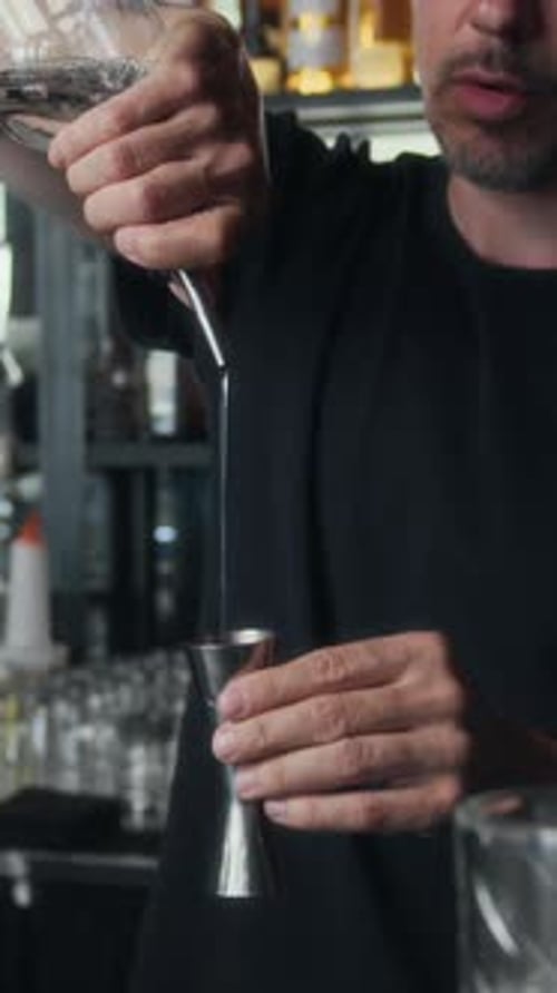 Barkeeper verwendet Jigger bei der Zubereitung von Cocktails in der Bar, vertikal