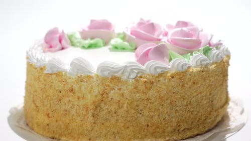 A cake with pink frosting and green leaves on top