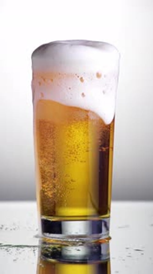 Foamy Beer in Glass With Dripping Suds