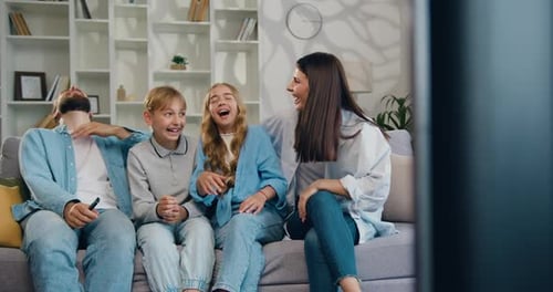 Happy Family Laughing Together While Watching Television