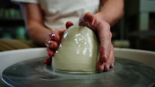 Crop of Unknown Man Artisan in Pottery Workshop Making Clay Pot on Rotary Machine