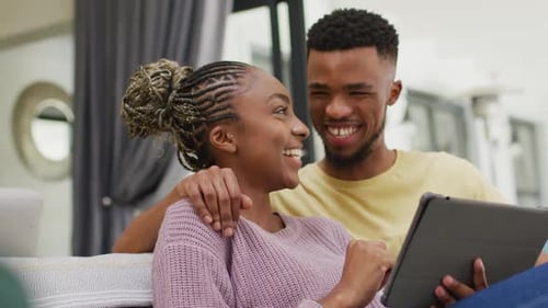 Happy Couple Using Tablet Together at Home