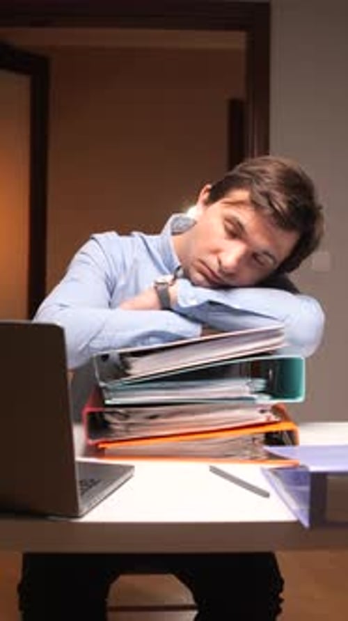 Exhausted Office Worker Sleeping on Documents at Desk