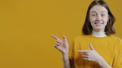 Smiling Young Adult Points to Copy Space