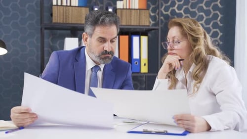 Colleagues Reviewing Documents in Workplace Setting