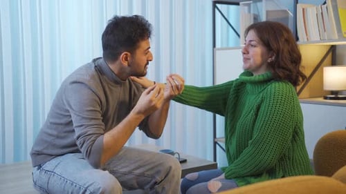 Woman Comforts Upset Man Indoors with Supportive Touch