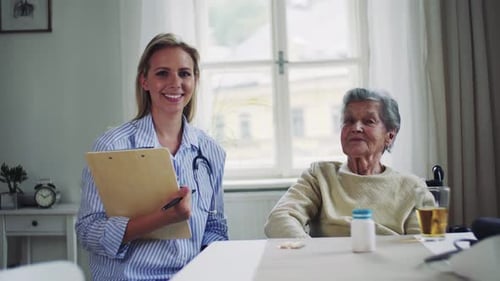 Young Woman Doctor and Senior Woman Sitting at Table