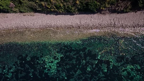 Aerial view of rocky beach and clear water, Italy.