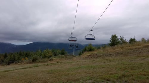Low angle shot of empty elevator cableway for people transportation along the mountain range on a
