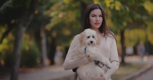Portrait of Woman Holding Her Dog in the Autumn Park