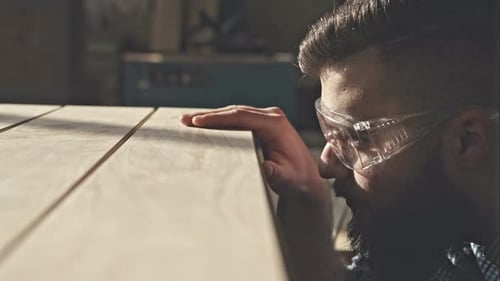 Woodworker Inspecting Quality of Wood in Workshop