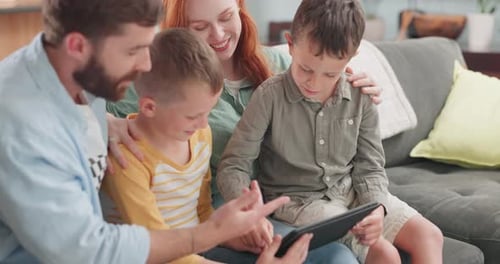Loving Family Using Tablet on Couch at Home