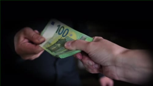 Hands exchanging stack of Euro banknotes