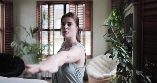 Young Woman Stretching in a Bright Home