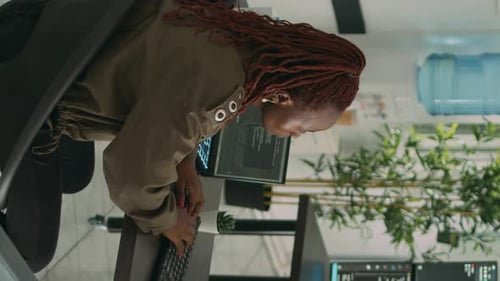 Programador afroamericano de Vídeo vertical que escribe el código fuente en la computadora