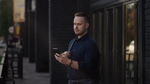 Modern Urban Man Uses a Smartphone on a City Street Internet Technologies Make It Easier to Access