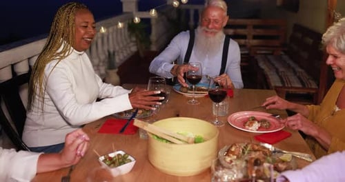 Friends Share Meal and Toast With Wine at Night