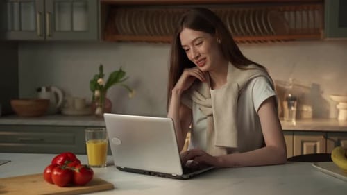 Woman Works on Laptop in Bright Kitchen