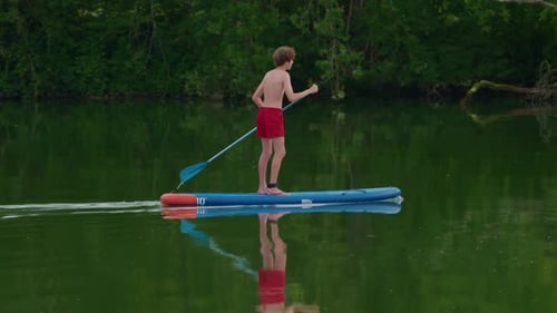 Teenager with Paddle on a Sup Floats on a Picturesque Lake Active Lifestyle Concept