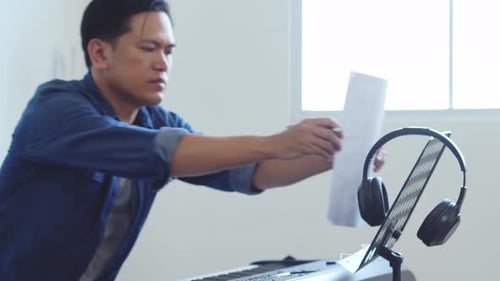 Hombre asiático componiendo notas musicales