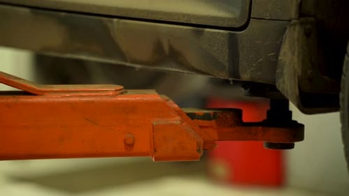 A Hydraulic Lift Lowers a Car at a Service Center