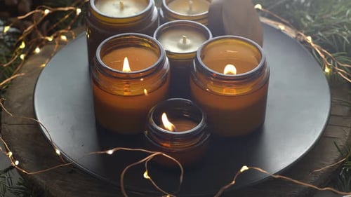 Burning Candles in Jars With Festive Decorations