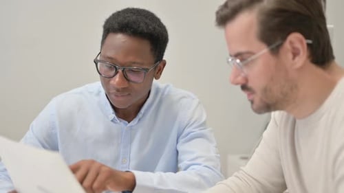 Close Up of Mixed Race Business People Discussing Business Report