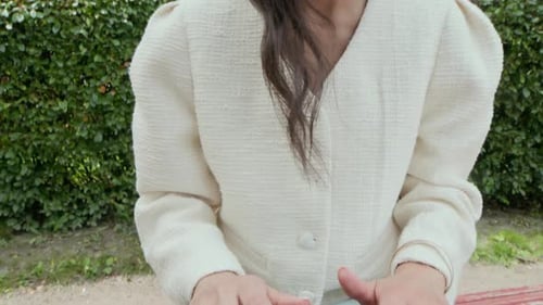 Young Woman Typing on her Laptop, While Working Outdoors in Park