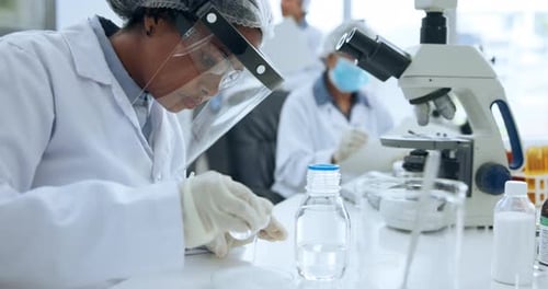 Scientists Working with Petri Dish and Microscope