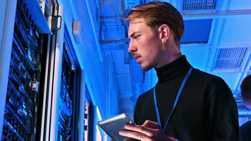 Young Adult Working With Tablet in Server Room