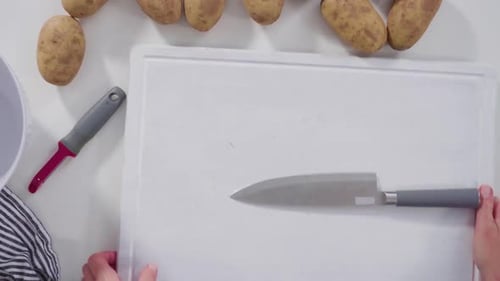 Time Lapse Flat Lay Step By Step Peeling Large Yellow Potatoes with a Vegetable Peeler on a White