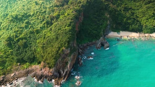 Aerial View of a Pristine Tropical Island with Lush Vegetation Covering Steep Cliffs That Meet the