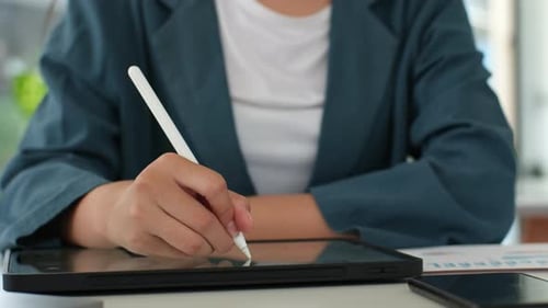Young Adult Using Tablet with Stylus at Desk