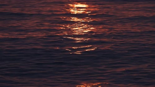 Blendung auf der Wasseroberfläche Goldener Sonnenuntergang schimmert auf der Meeresoberfläche und erzeugt eine