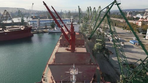 Aerial View of Big Cargo Ship Bulk Carrier is Loaded with Grain of Wheat in Port at Sunset