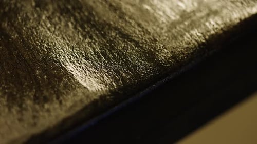 Commercial shot showing textured black painted wood on table edge
